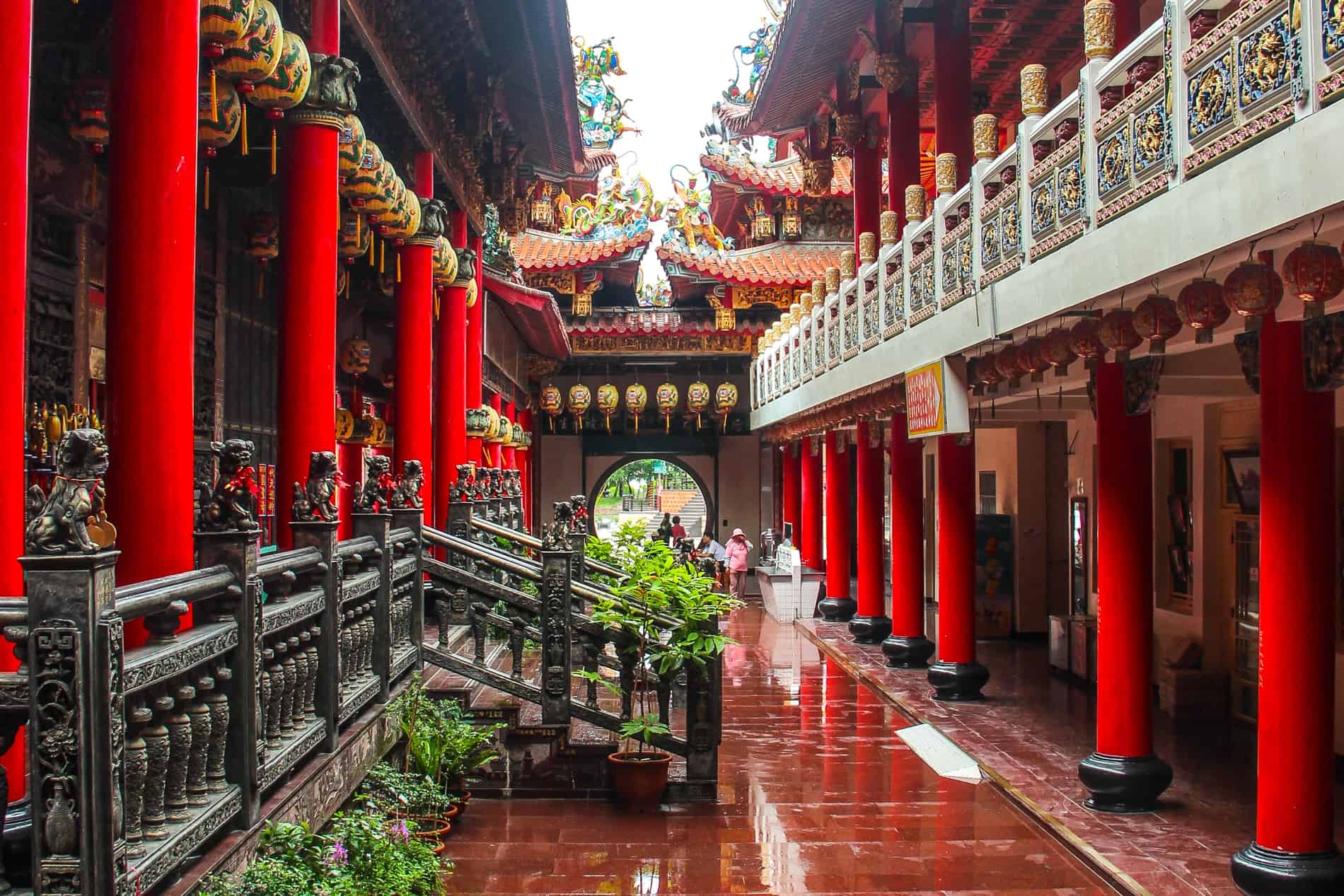 Inside the Luermen Matsu Temple in Tainan with red columns, carved stairs cases and balconies and yellow lanterns. 