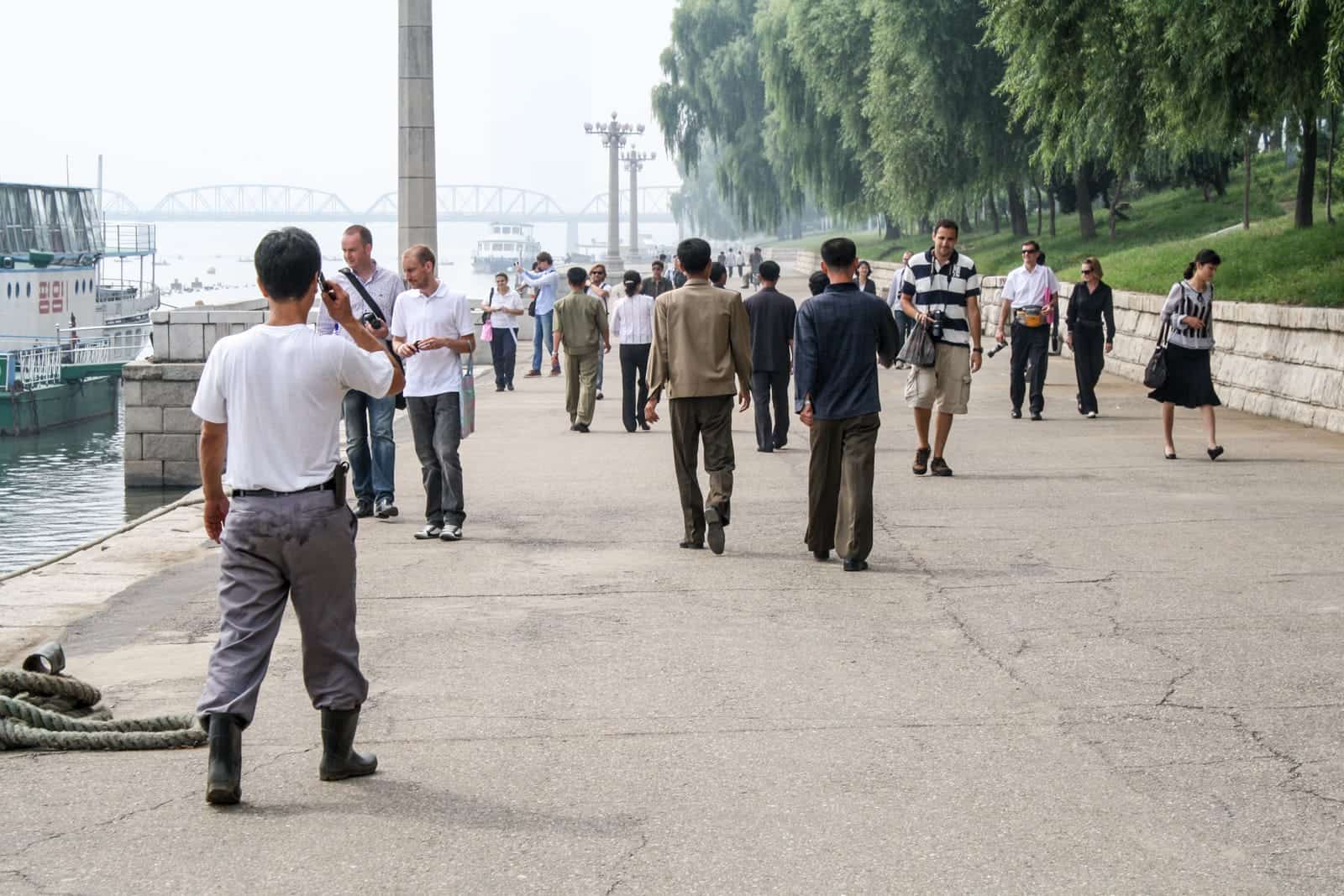 Tourists walk in Pyongyang city on a North Korea tour