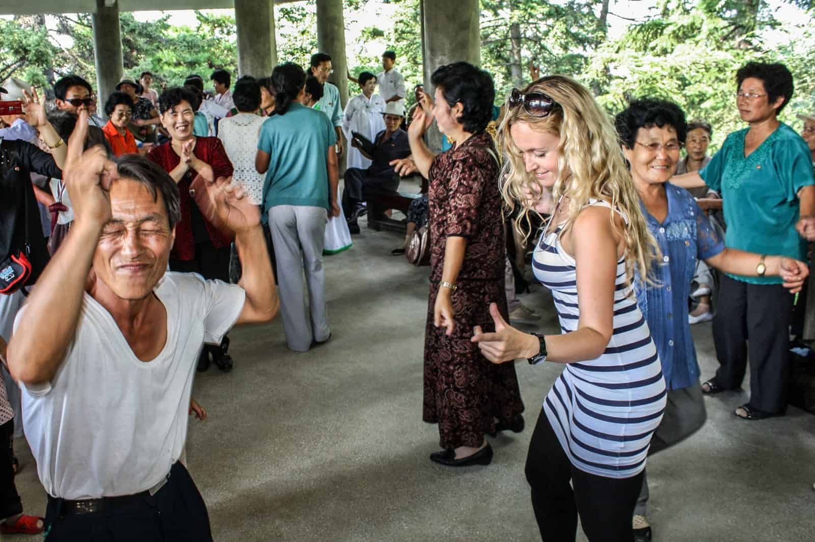 Tourist dances with a North Korean on National Day in Pyongyang, DPRK - the limited interaction allowed