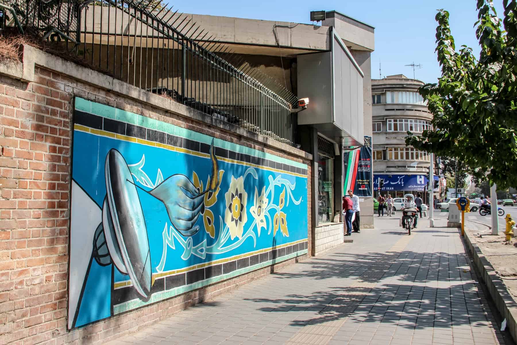 A long blue mural on a brick wall in Tehran Iran. 
