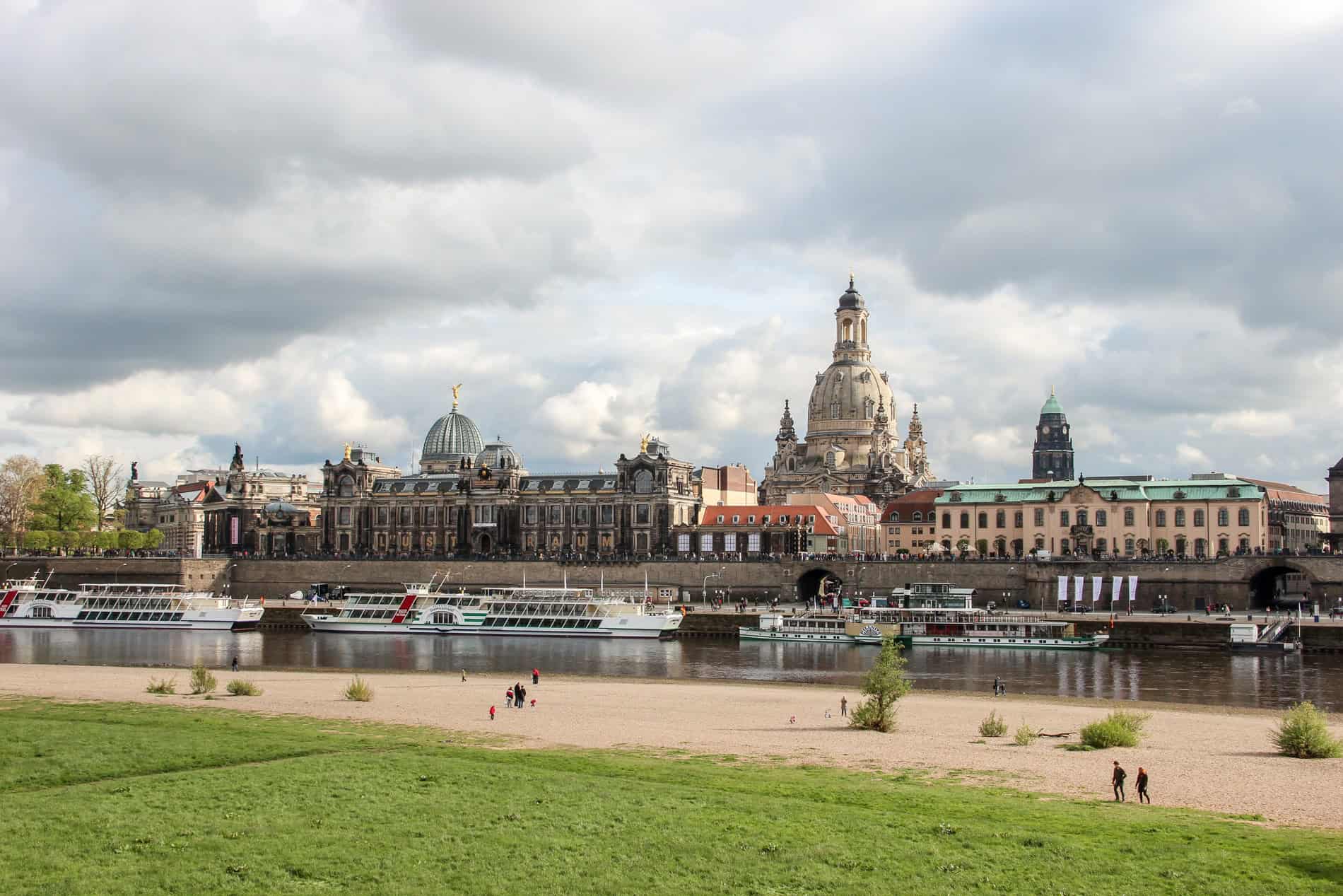 View of Dresden Aldstadt (old town) opulent architecture from the banks of the River Elbe lined with boats. 