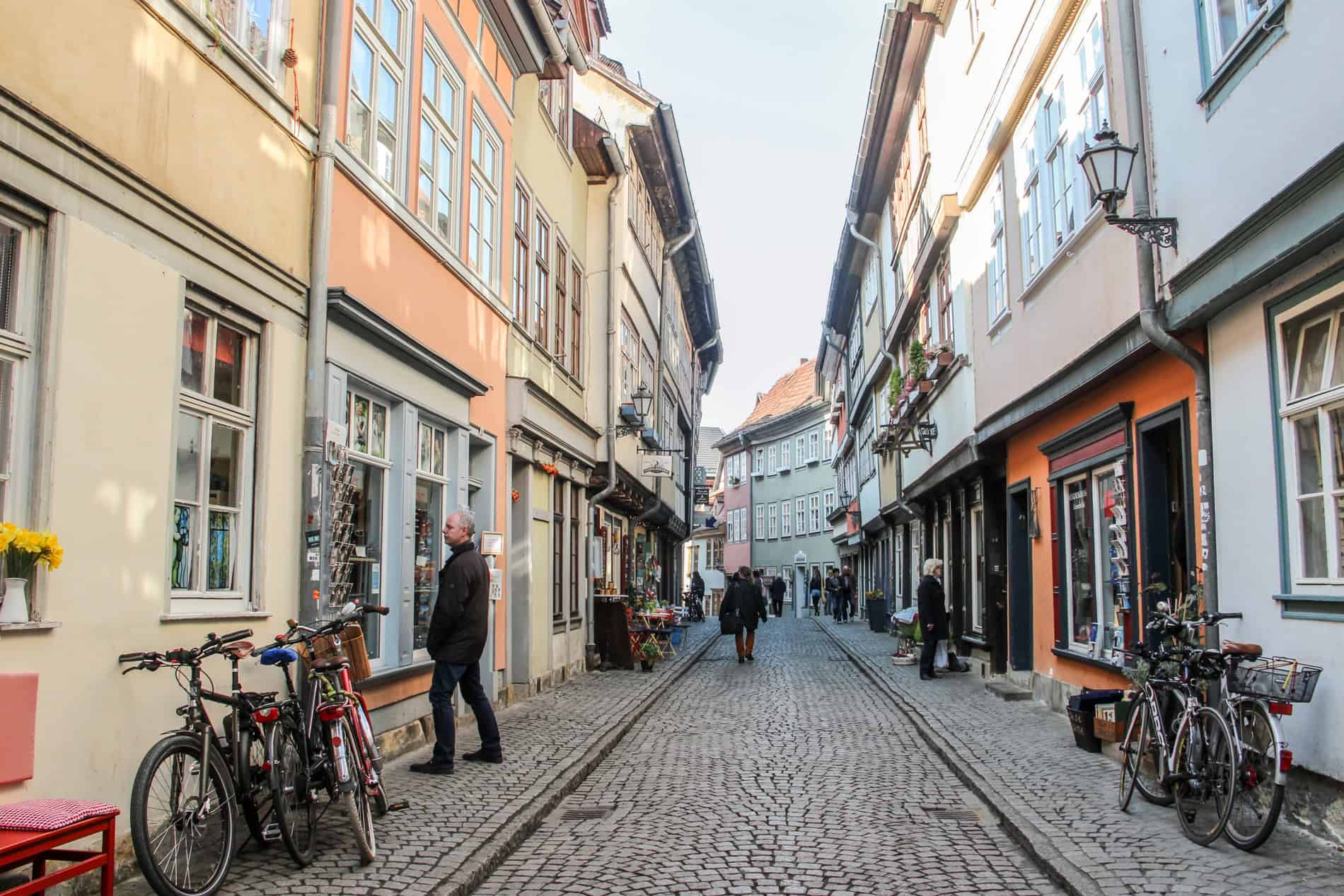 People walking on a cobbled street of galleries and shops on the Krämerbrücke bridge street in the German city of Erfurt. 